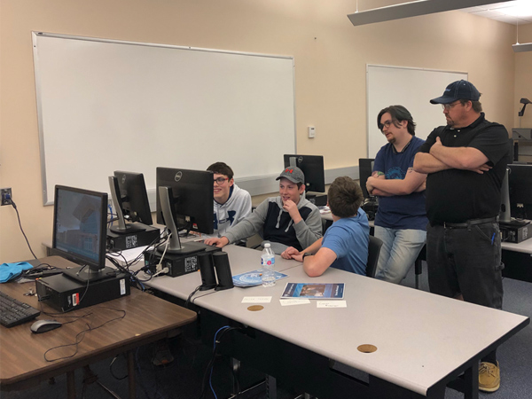 Student and Professor Assisting in Cyber Camp
