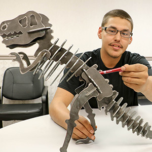 GFC MSU grad put finishing touches on new T-rex sculpture